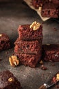 Stack of delicious brownie pieces with hazelnuts on dark background Royalty Free Stock Photo
