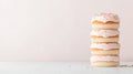 Stack of delicious donuts with pink icing and colorful sprinkles on a pastel background, simple dessert presentation. Royalty Free Stock Photo