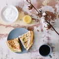 Stack of delicious homemade pancakes on plate with honey, sour cream and tea. Breakfast. Rustic style, close up top view. Flat lay Royalty Free Stock Photo