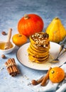Stack of delicious pumpkin fluffy pancakes with maple syrup or honey and nuts. Healthy breakfast. Autumn food. Blue background Royalty Free Stock Photo