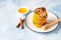 Stack of delicious pumpkin fluffy pancakes with maple syrup or honey and nuts. Healthy breakfast. Autumn food. Blue concrete Royalty Free Stock Photo