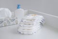 A stack of diapers and baby supplies on white changing table Royalty Free Stock Photo