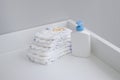 A stack of diapers and baby supplies on white changing table Royalty Free Stock Photo