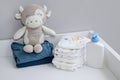 A stack of diapers, blue onesies and baby supplies on changing table Royalty Free Stock Photo