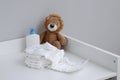 A stack of diapers, plush lion and baby supplies on changing table Royalty Free Stock Photo