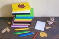 Stack of  different books, autumn leaves and colored pencils on table Royalty Free Stock Photo