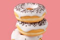 Stack of different chocolate glazed donut with sprinkles on a pink background Royalty Free Stock Photo