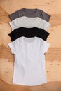 Stack of different coloured womens T-shirt on wooden background