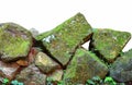 Stack of different shape of stones covered with green moss, isolated on white background