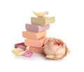 Stack of different soap bars with rose on white background