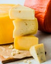 Stack of assorted cheeses isolated on wood board. Whole wheel of cheese background Royalty Free Stock Photo