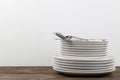 A stack of dishes. tableware on a brown wooden table. plates and cutlery. with space for text Royalty Free Stock Photo