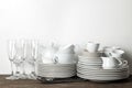 A stack of dishes. tableware on a brown wooden table. dishes for serving the table. plates and cutlery, cups and teapot, glasses. Royalty Free Stock Photo