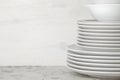 A stack of dishes. tableware on a light concrete background. dishes for serving the table. white plates and bowls in a stack. spac Royalty Free Stock Photo