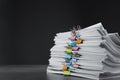 Stack of documents with binder clips on stone table against black background, space for text Royalty Free Stock Photo