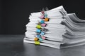 Stack of documents with binder clips on grey stone table