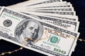Stack of 100 dollar bills and gold jewelry on a dark background Royalty Free Stock Photo