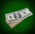 Stack of dollars on grunge green background