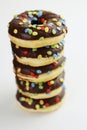 A stack of doughnuts glazed with chocolate and colorful smarties. Pile of 5 donuts isolated on a white background. Side view. Copy Royalty Free Stock Photo