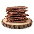 Stack of dried beef jerky slices on a wooden platter with a natural edge Royalty Free Stock Photo