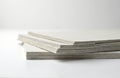 Stack of drywall boards on white background. Construction material for repairs, renovation. Gypsum plasterboard sheets stacked to Royalty Free Stock Photo
