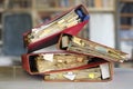 stack of dusty messy file folders with narrow depth of field, blurred office in the back,red tape, bureaucracy,aministration,