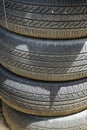 Stack of dusty old used car tyres showing groove lines
