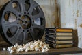 stack of dvds beside a film reel and popcorn on a shelf Royalty Free Stock Photo