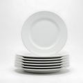 Stack of elegant white dinner plates isolated on white background Royalty Free Stock Photo