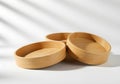 Stack of Empty Bamboo Bowls on White Surface with Window Shadows Royalty Free Stock Photo