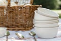 stack of empty ice cream bowls with spoons by a picnic basket Royalty Free Stock Photo