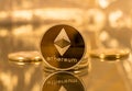 Stack of ethereum coins with gold background