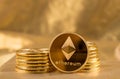 Stack of ethereum coins with gold background