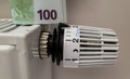 A stack of 100 euro banknotes on the thermostat temperature controller of a radiator battery Royalty Free Stock Photo