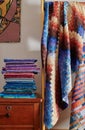 Stack of fabriÃÂs and quilt made in the bargello style on white wall background