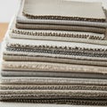 A stack of fabric swatches in neutral tones, including beige, cream, and gray. Each Royalty Free Stock Photo
