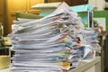 Stack of files full of documents signifying