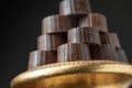 Stack of Fine Chocolates On Golden Pillar Dish With Dark Background