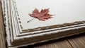 A stack of fine, textured, deckle-edged paper lies on a wooden surface Royalty Free Stock Photo