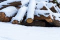 Stack of firewood covered with snow outdoors. Stack of wood cut. Snow on the timber stack. Wooden log store under snow white Royalty Free Stock Photo