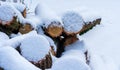 Stack of firewood covered with snow outdoors. Stack of wood cut. Snow on the timber stack. Wooden log store under snow white Royalty Free Stock Photo