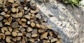 Stack of firewood near stone wall. Natural wooden pattern background. Royalty Free Stock Photo