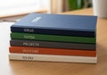 A stack of five hardcover notebooks is arranged on a wooden surface. Each notebook Royalty Free Stock Photo