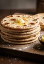 A stack of flatbread, likely naan or pita, is displayed on a wooden surface. The bread is Royalty Free Stock Photo