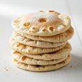 Stack of flatbreads, possibly pita, on a white surface. Each piece features small Royalty Free Stock Photo