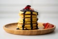 A stack of fluffy breakfast american pancakes with strawberries and chocolate sauce syrup pouring from the top Royalty Free Stock Photo