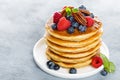 Stack of fluffy pancakes with fresh berries and pecan nuts