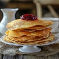 Stack of fluffy pancakes topped with red fruit jam on white ceramic stand on wooden rustic table Royalty Free Stock Photo