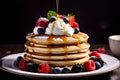 Stack fluffy pancakes topped with syrup, berries, and a dollop of whipped cream. Morning vibes for sweet food lovers