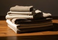 Stack of folded beige and white towels on wooden surface in warm light Royalty Free Stock Photo